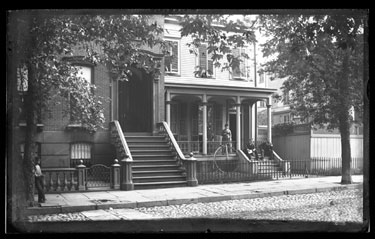 USA: View of cobbled street- wooden houses with stairs and porches