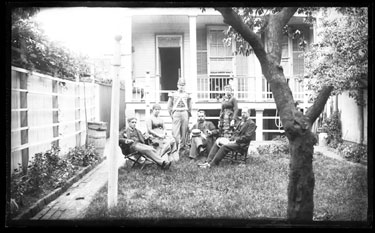 USA: View of back garden looking onto house with a group of men and women
