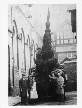 Stall holders with a Christmas tree in Hamilton Place, by Market Hall