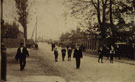 View: c08783 Helsby: Men and children walk along an unknown street.