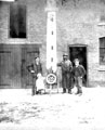 View: p1763 Four people with model lighthouse mounted on a tricycle for a parade.