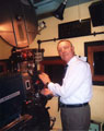View: p4198 Colour photograph of projectionist Fred Sheldon in projection box of Odeon Cinema