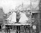 View: p4717 Two men with model ships mounted on bicycles or tricycles for a parade